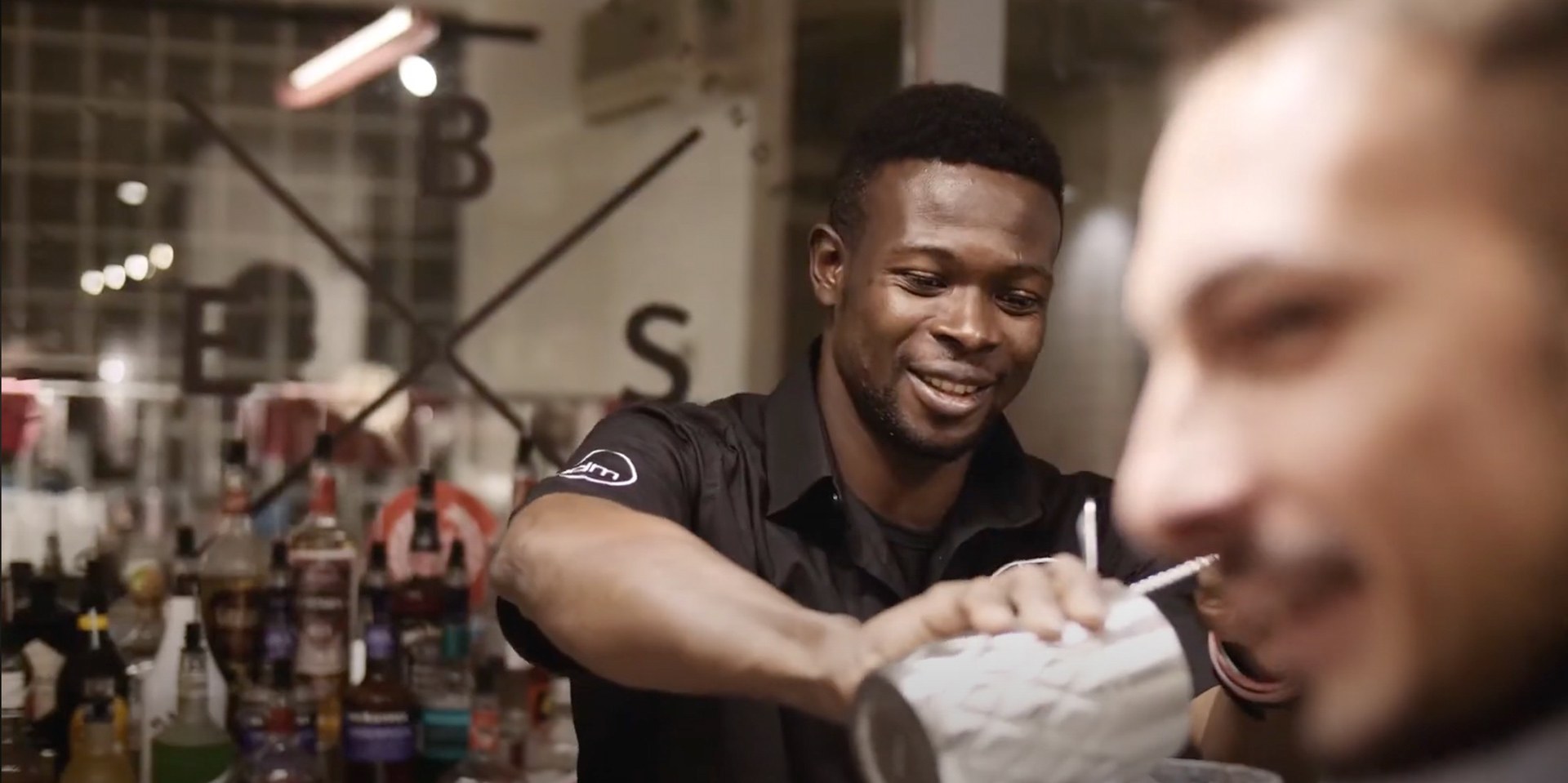 A smiling bartender shakes a cocktail for a guest, Shake Your Future for Bacardi by Joris Skudra