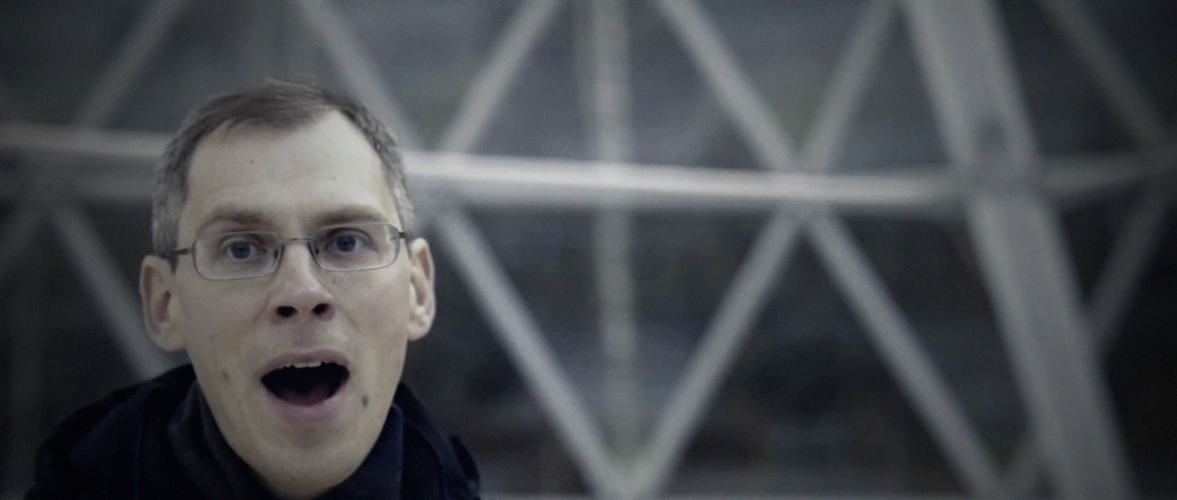 A man sings with his eyes wide open inside the glass meditation dome, The Dome for Atlas Obscura by Joris Skudra