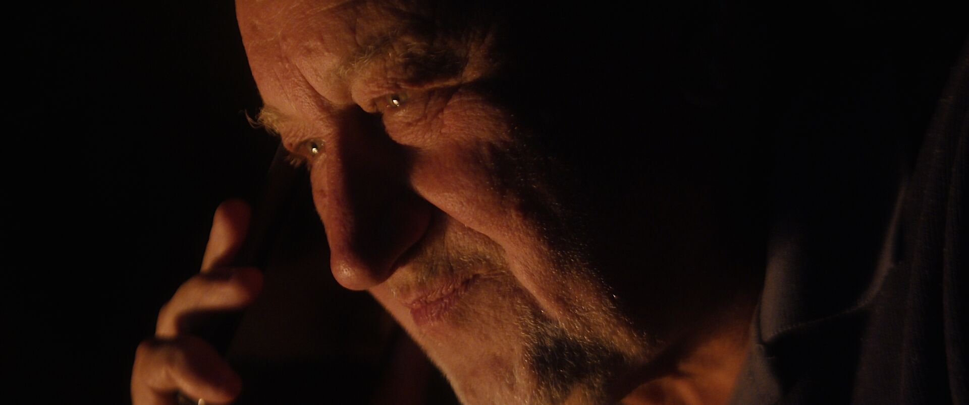 Romualdas Požerskis in warm light, close-up, Under the Red Light