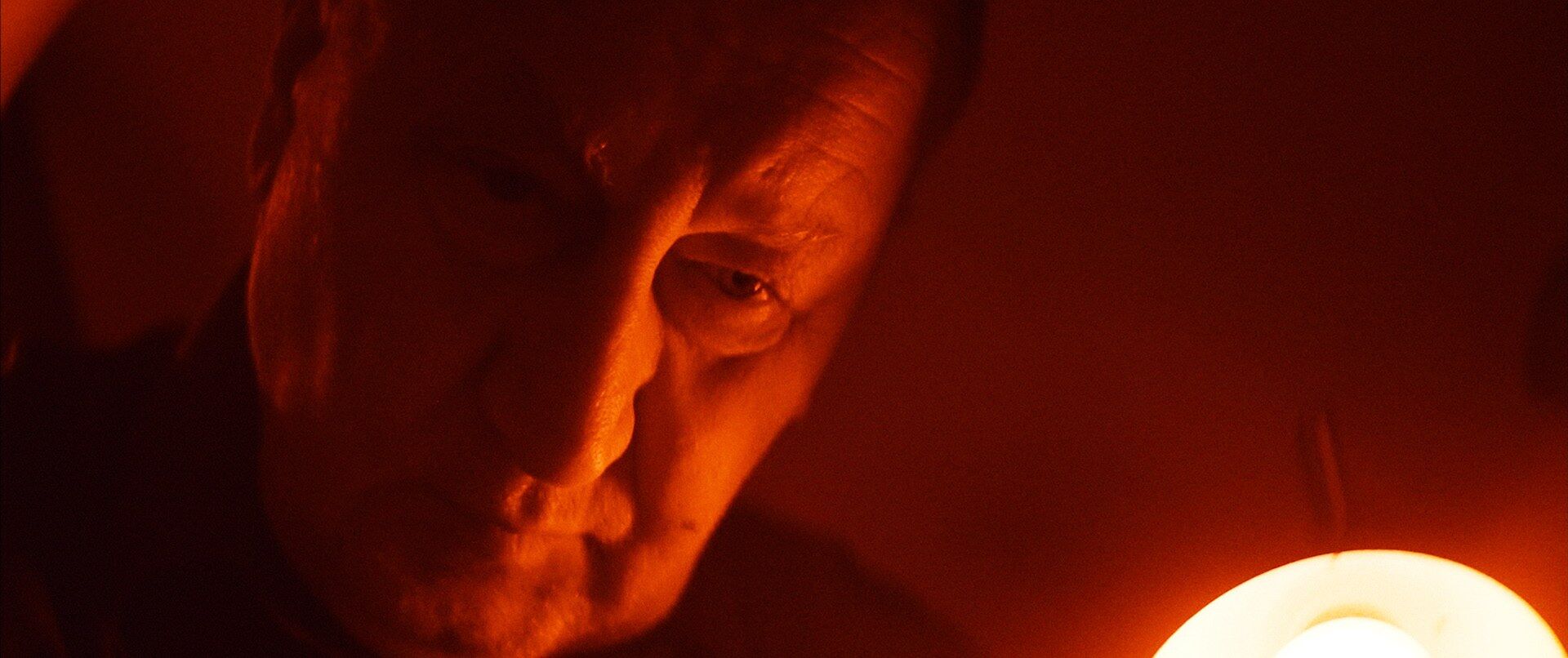 Romualdas Požerskis lit by the darkroom safelight, Under the Red Light